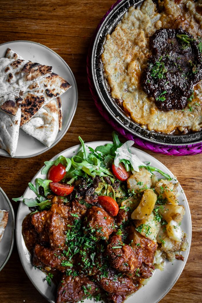 A mouth-watering display of Mediterranean dishes including grilled meat, bread, and fresh vegetables.