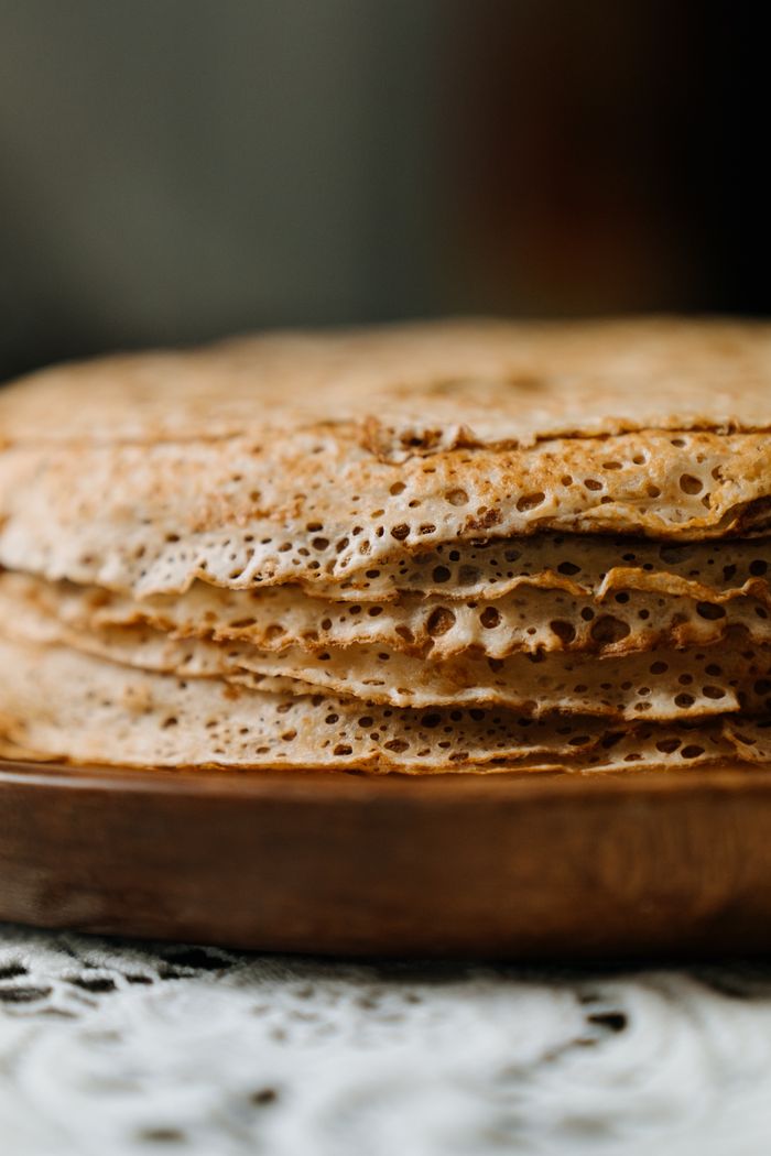 Close-up of a delicious stack of traditional Russian bliny, showcasing their texture.